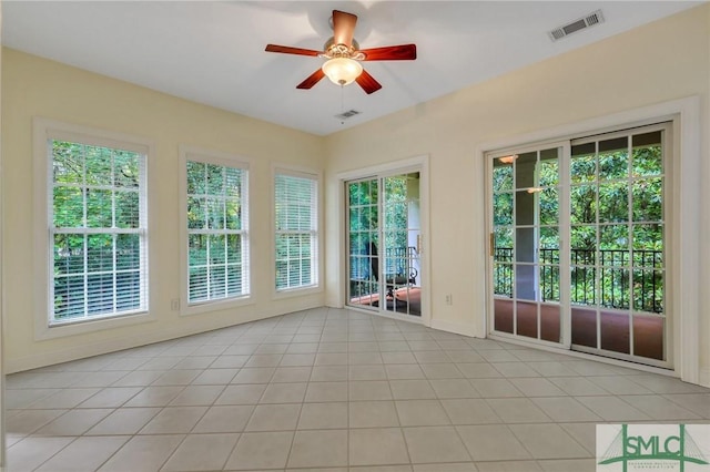 unfurnished sunroom featuring ceiling fan