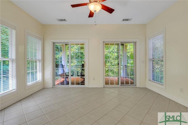 empty room with ceiling fan and light tile patterned flooring