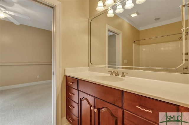 bathroom featuring crown molding, a shower, ceiling fan, and vanity