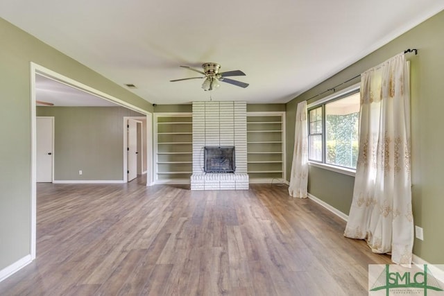 unfurnished living room with a fireplace, ceiling fan, and light wood-type flooring