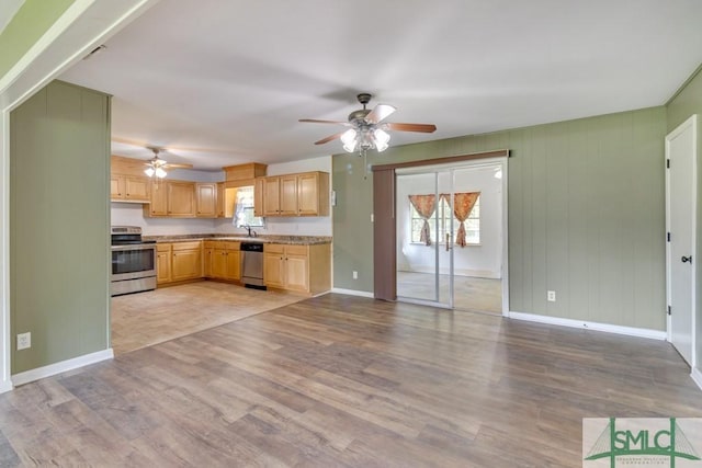 kitchen with appliances with stainless steel finishes, light brown cabinetry, sink, ceiling fan, and light wood-type flooring