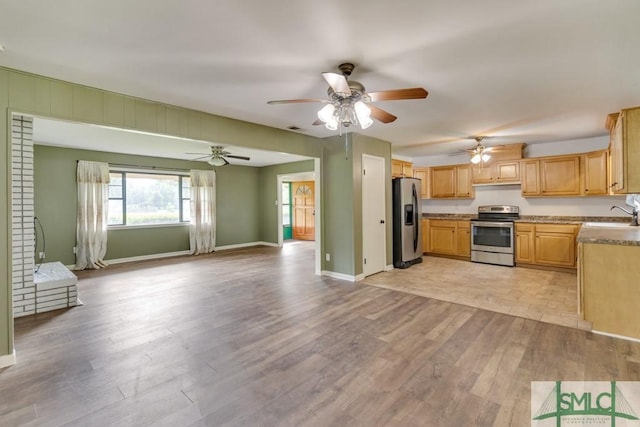 kitchen with light brown cabinetry, sink, ceiling fan, stainless steel appliances, and light hardwood / wood-style flooring