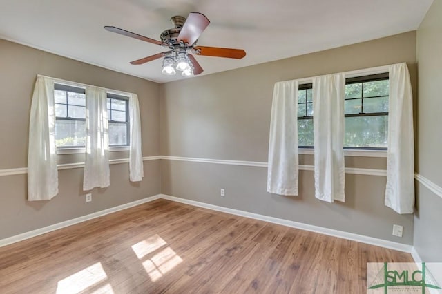 spare room with plenty of natural light, ceiling fan, and light hardwood / wood-style flooring