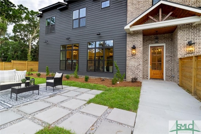 rear view of house with an outdoor hangout area and a patio area