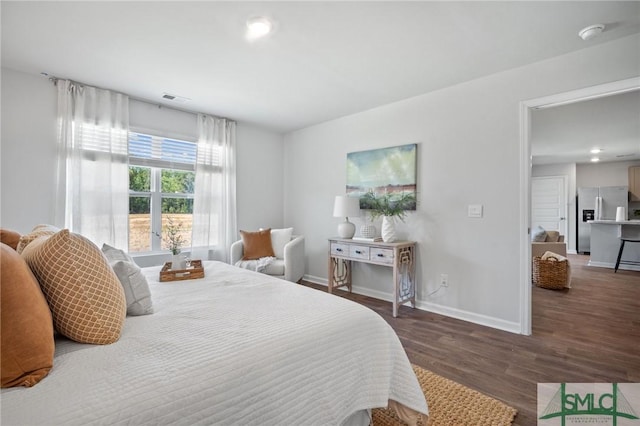 bedroom featuring stainless steel fridge and dark hardwood / wood-style flooring