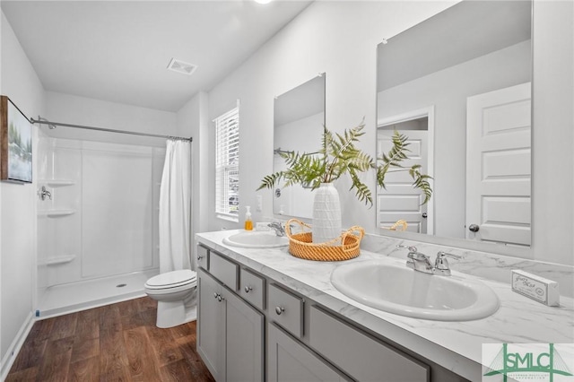 bathroom featuring vanity, hardwood / wood-style floors, toilet, and walk in shower