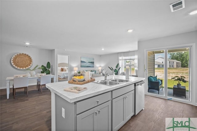 kitchen featuring sink, gray cabinetry, dark hardwood / wood-style floors, an island with sink, and stainless steel dishwasher