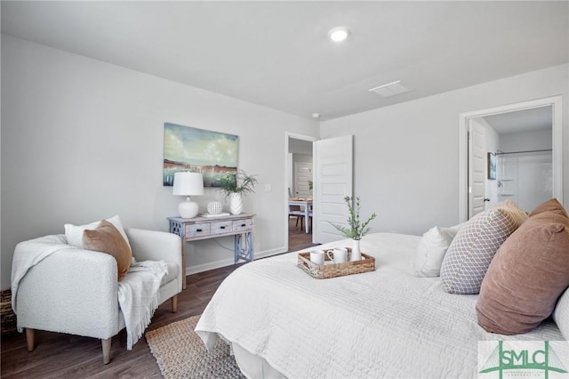 bedroom with dark wood-type flooring and ensuite bathroom