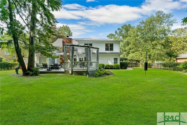 back of property with a wooden deck and a lawn