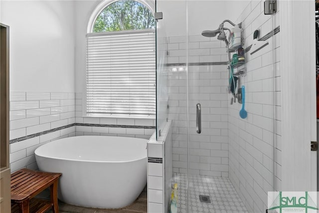 bathroom featuring separate shower and tub and tile walls