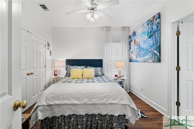 bedroom with dark hardwood / wood-style flooring and ceiling fan