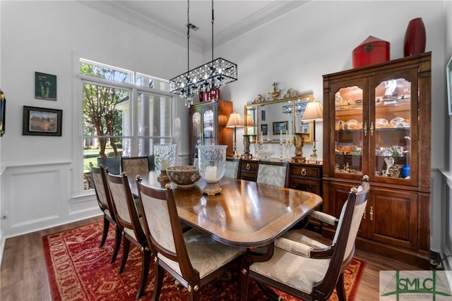 dining room featuring crown molding, dark wood-type flooring, and a chandelier