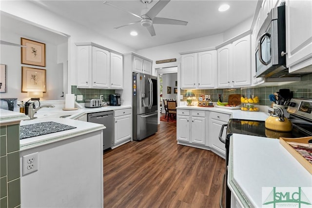 kitchen featuring white cabinetry, appliances with stainless steel finishes, dark wood-type flooring, and decorative backsplash