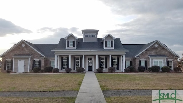 view of front of house featuring covered porch and a front yard