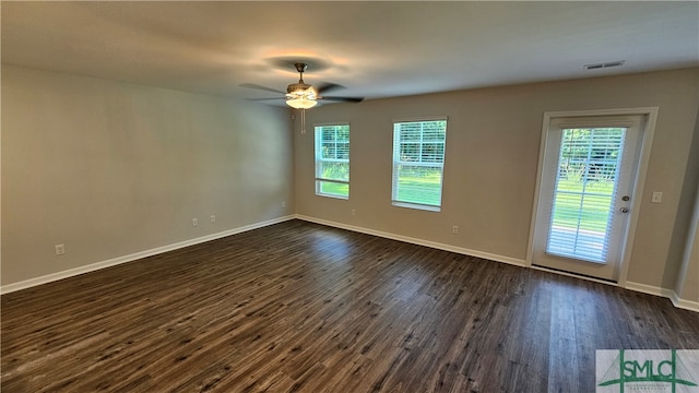 unfurnished room featuring plenty of natural light, dark hardwood / wood-style flooring, and ceiling fan