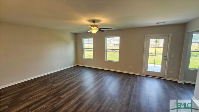 unfurnished room featuring dark wood-style flooring, visible vents, ceiling fan, and baseboards