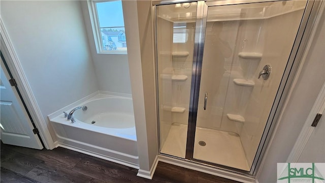 full bath with a shower stall, a bath, and wood finished floors