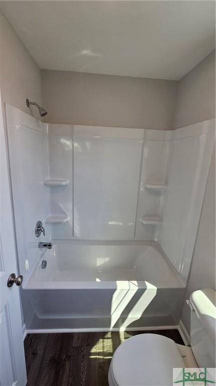 full bathroom featuring bathtub / shower combination, toilet, and wood finished floors