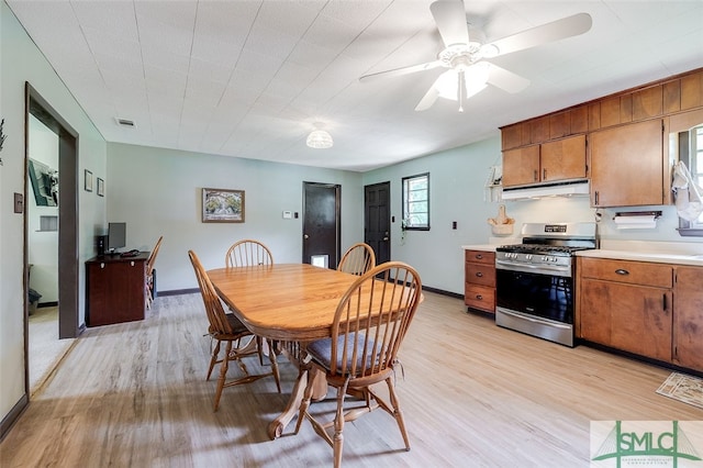 kitchen featuring gas stove, light hardwood / wood-style floors, ventilation hood, and ceiling fan