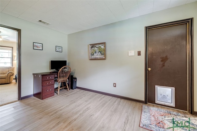 home office featuring ceiling fan and light hardwood / wood-style flooring