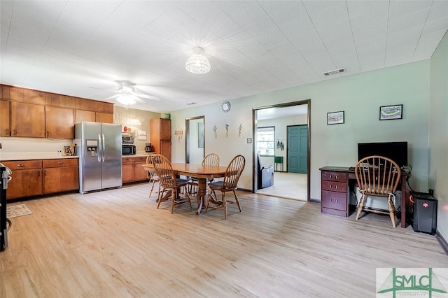 dining space with ceiling fan and light wood-type flooring