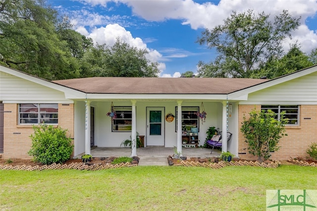 ranch-style house featuring a porch and a front yard