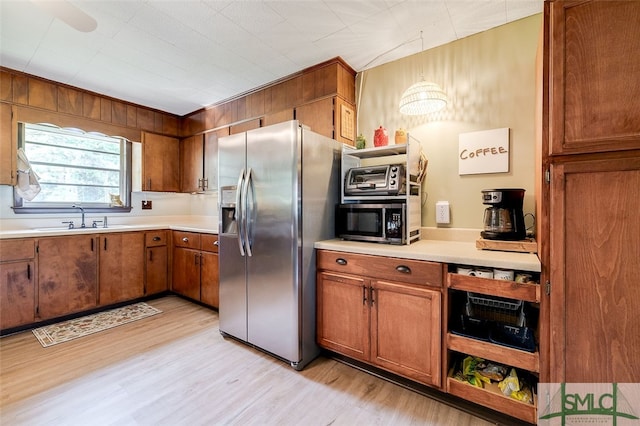 kitchen featuring stainless steel appliances, light hardwood / wood-style flooring, sink, and ceiling fan