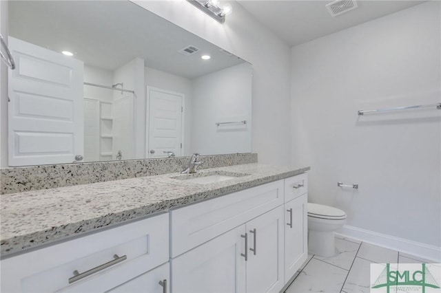 bathroom featuring vanity, toilet, and walk in shower