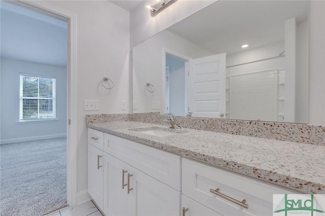 bathroom featuring tile patterned flooring, vanity, and walk in shower