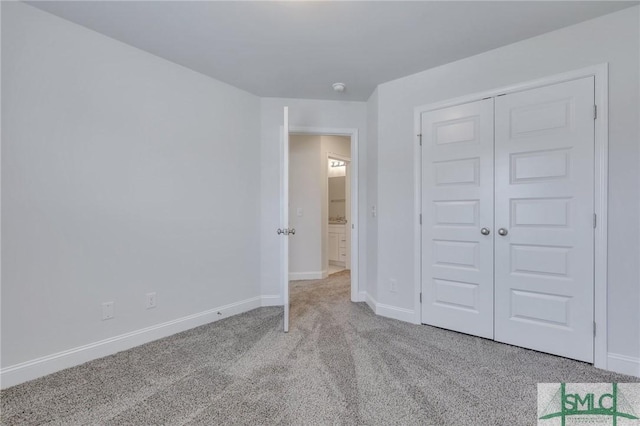 unfurnished bedroom with light colored carpet and a closet