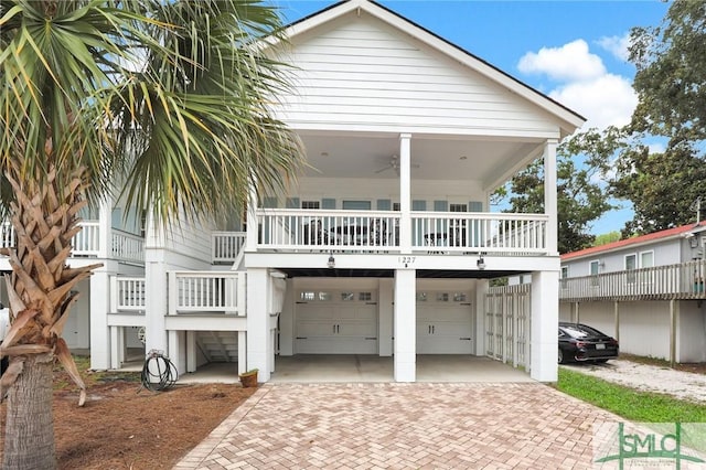 view of front facade with a garage, a balcony, and ceiling fan