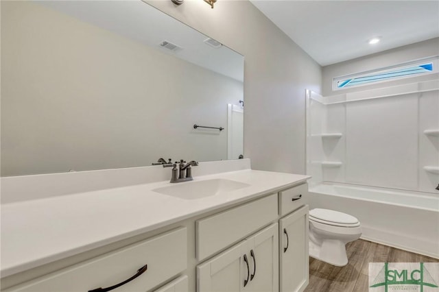 full bathroom with vanity, hardwood / wood-style flooring, shower / bathtub combination, and toilet