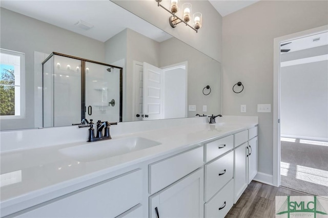 bathroom with vanity, a shower with door, and wood-type flooring