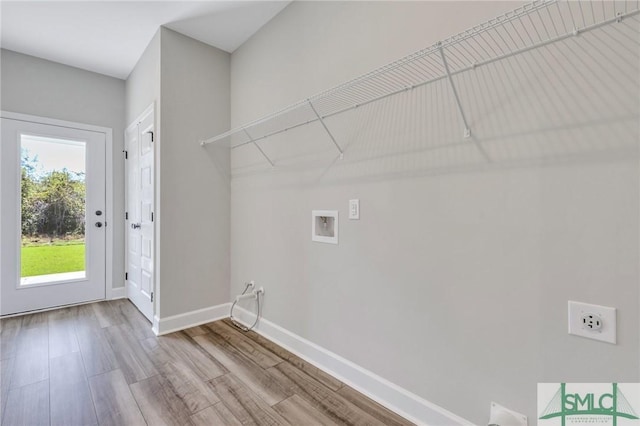 laundry room featuring electric dryer hookup, hookup for a washing machine, and light wood-type flooring