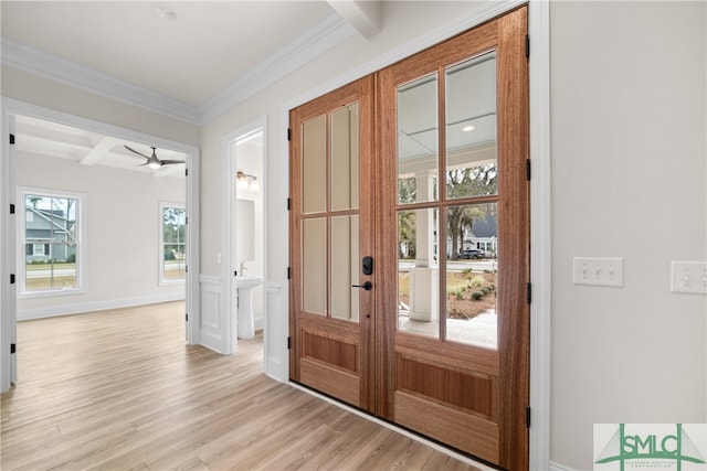 doorway to outside with ceiling fan, light hardwood / wood-style floors, beam ceiling, and a wealth of natural light