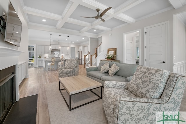 living room with ceiling fan, ornamental molding, and light hardwood / wood-style flooring