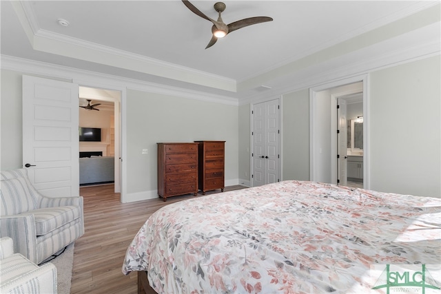 bedroom featuring connected bathroom, ceiling fan, crown molding, and light hardwood / wood-style floors