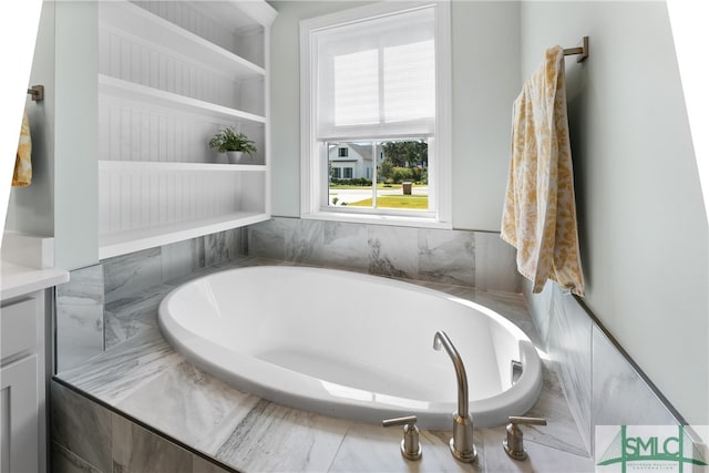 bathroom with vanity and a relaxing tiled tub