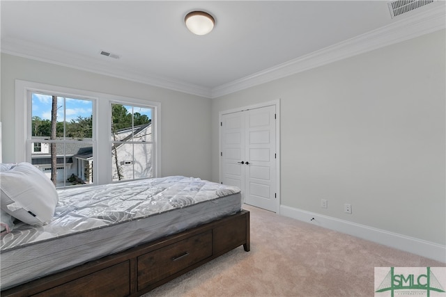 carpeted bedroom featuring ornamental molding and a closet