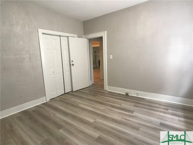 unfurnished bedroom featuring a closet and wood-type flooring