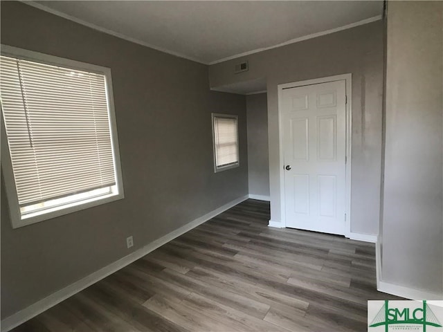 unfurnished room with plenty of natural light, hardwood / wood-style floors, and ornamental molding