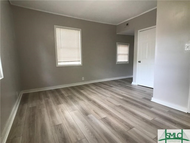 unfurnished room featuring crown molding and wood-type flooring