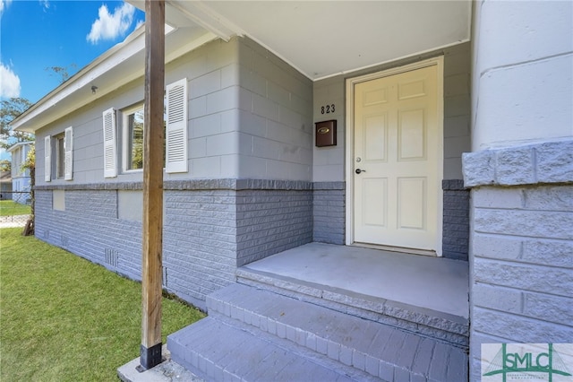 entrance to property featuring a yard