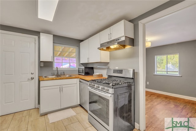 kitchen featuring white cabinets, stainless steel appliances, sink, and a wealth of natural light