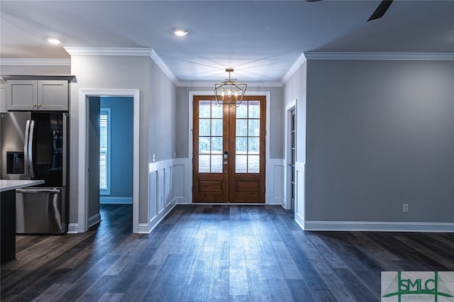 foyer with ceiling fan with notable chandelier, french doors, dark hardwood / wood-style flooring, and ornamental molding