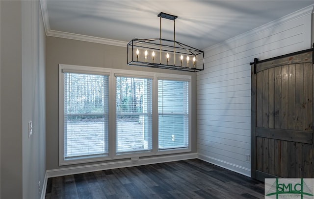 unfurnished dining area with an inviting chandelier, a barn door, crown molding, and dark wood-type flooring