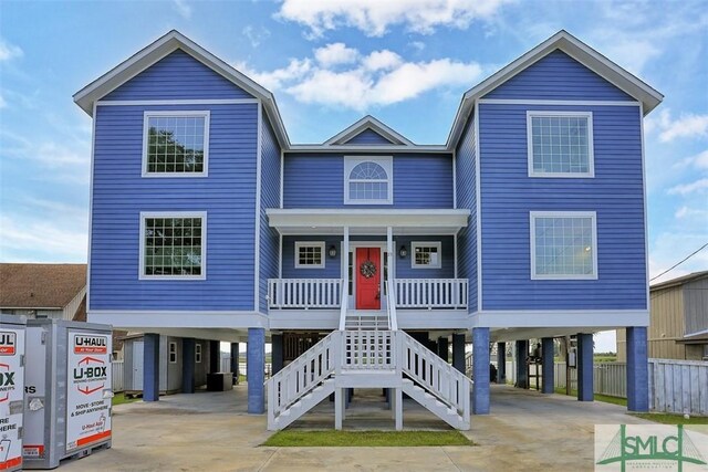 coastal inspired home featuring a carport, central AC, and a porch