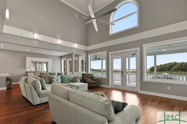 living area featuring baseboards, a ceiling fan, dark wood-type flooring, and french doors