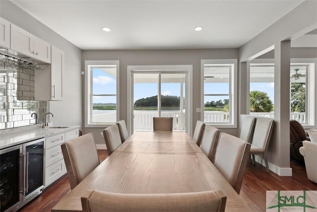 dining space with wine cooler, a healthy amount of sunlight, dark wood finished floors, and recessed lighting