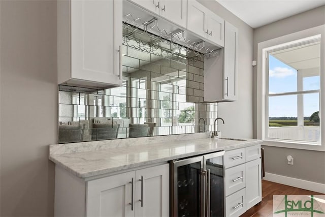 bar with beverage cooler, a sink, baseboards, backsplash, and dark wood-style floors